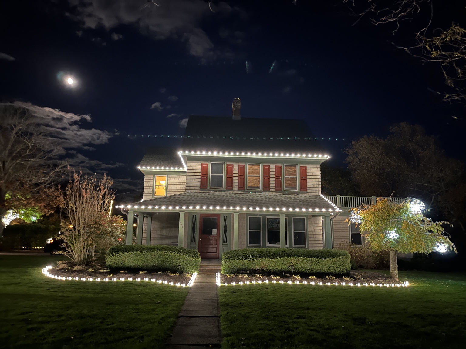 Warm white Christmas roofline and landscape lighting by Calais Flower